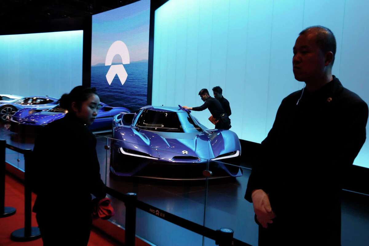In this Wednesday, April 19, 2017 photo, workers clean the $1.5million NIO EP9 displayed at the Shanghai auto show. NIO is part of a wave of fledgling automakers - all backed at least in part by Chinese investors - that are propelling the electric vehicle industry's latest trend: ultra-high-performance cars. (AP Photo/Ng Han Guan)
