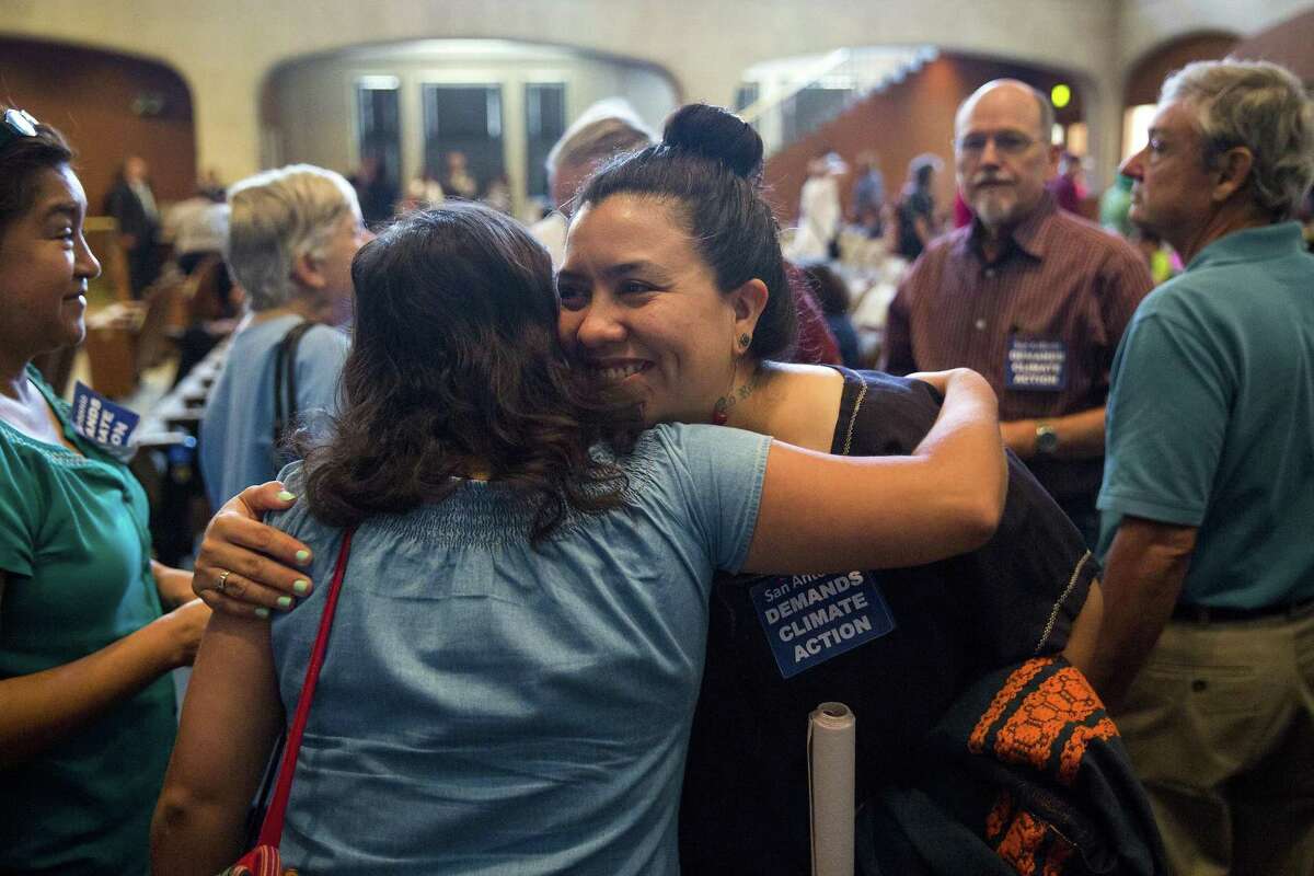 Jessica O. Guerrero, center, embraces a fellow Vecinos de Mission Trails member after the city council passed a resolution in support of the Paris Climate Agreement during a city council meeting at the Municipal Plaza building in San Antonio, Texas on June 22, 2017. Ray Whitehouse / for the San Antonio Express-News
