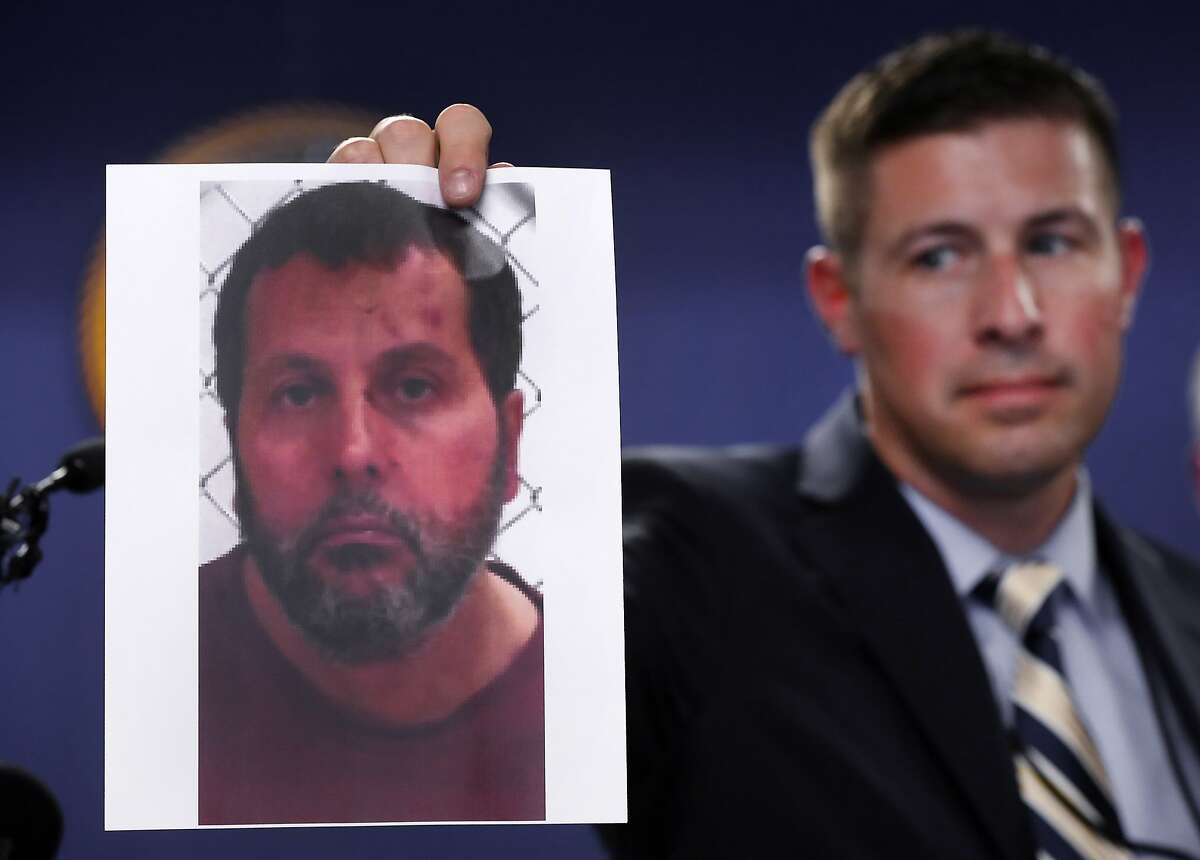 Timothy Wiley, FBI public affairs specialist, holds a photo Amor Ftouhi after a news conference in Detroit, Thursday, June 22, 2017. Amor Ftouhi, a Canadian man, shouted in Arabic before stabbing a police officer in the neck at the Bishop International Airport in Flint, Mich., on Wednesday, and referenced people being killed overseas during the attack that's now being investigated as an act of terrorism, federal officials said. (AP Photo/Paul Sancya)