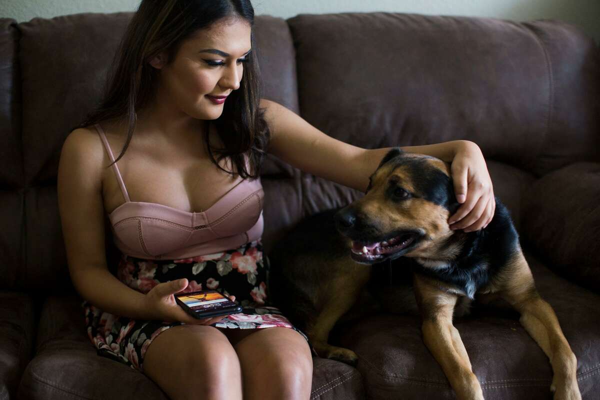 Catizia plays with her dog Maxy, who she says eases her anxiety, at her boyfriend's apartment in San Antonio, Texas on June 3, 2017.