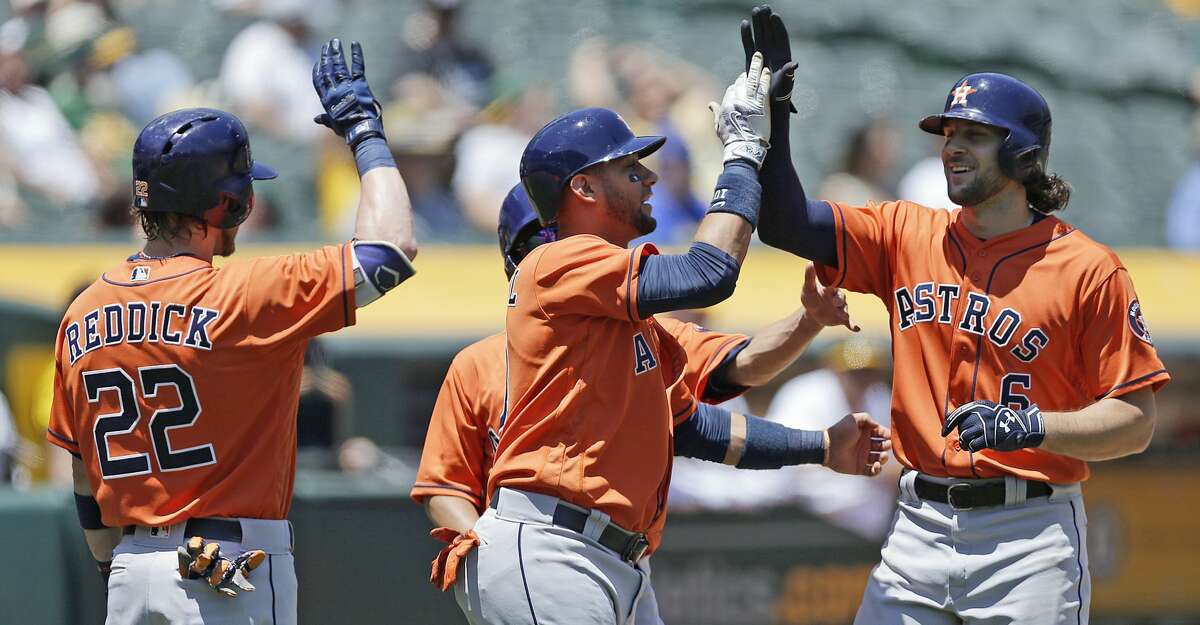 Houston Astros' Jake Marisnick, right, is congratulated by Josh Reddick (22) and Yuli Gurriel, center, after hitting a three-run home run off Oakland Athletics pitcher Jesse Hahn in the first inning of a baseball game Thursday, June 22, 2017, in Oakland, Calif. (AP Photo/Ben Margot)