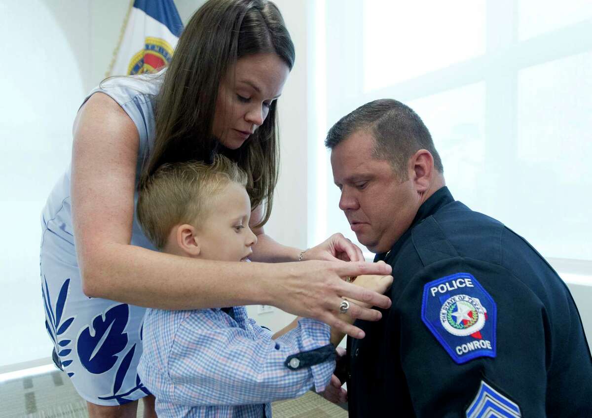 Jermy Allen, right, gets some help from his girlfriend Krista Lorenz as son R.J. pins on his sergeant rank during a Conroe Police Department promotional ceremony Thursday, June 22, 2017, in Conroe.