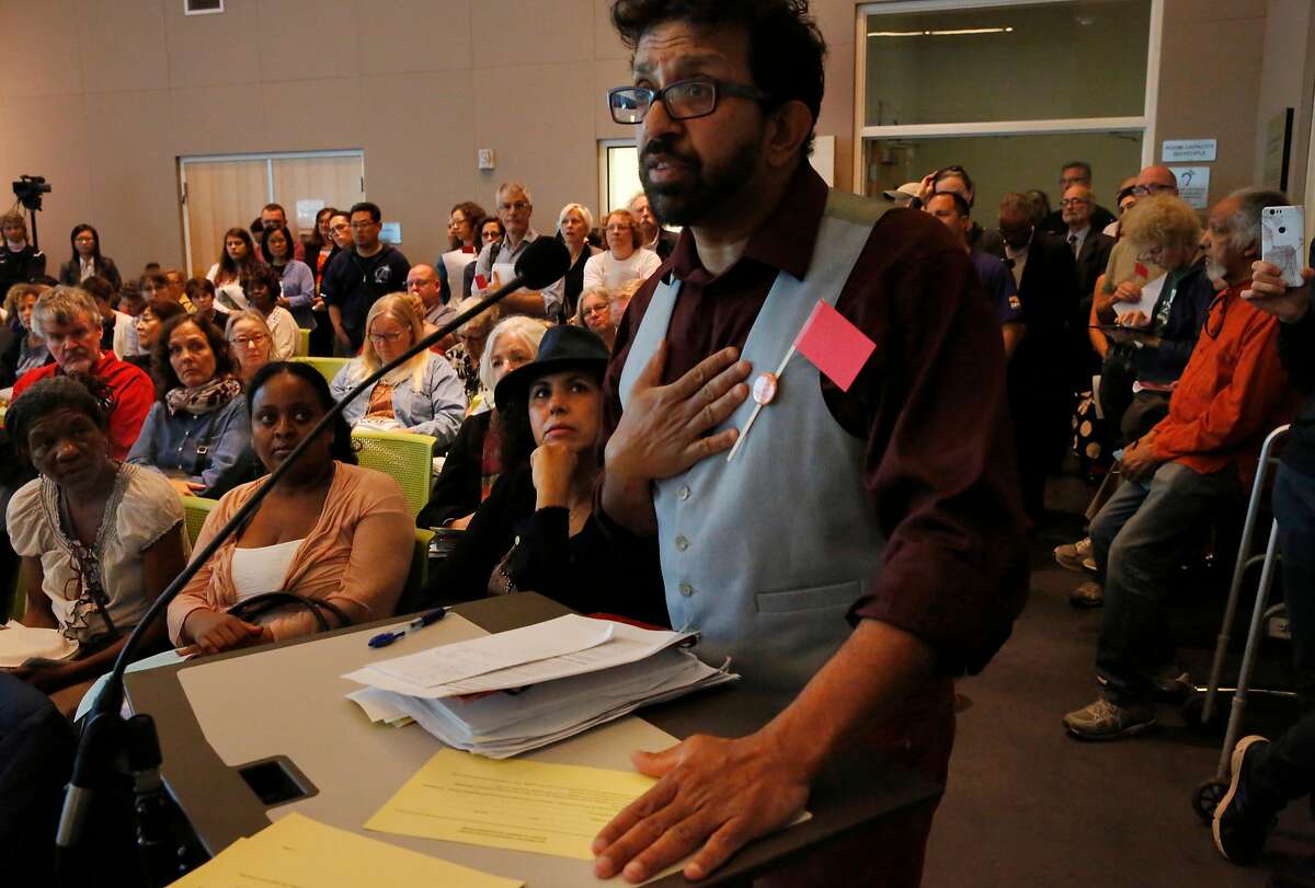 Community members listen as faculty member and librarian Alan D'Souza testifies against the new chancellor pick during a CCSF board of trustees meeting to vote to approve the new chancellor, Mark Rocha, in the multi-use building June 22, 2017 in San Francisco, Calif.