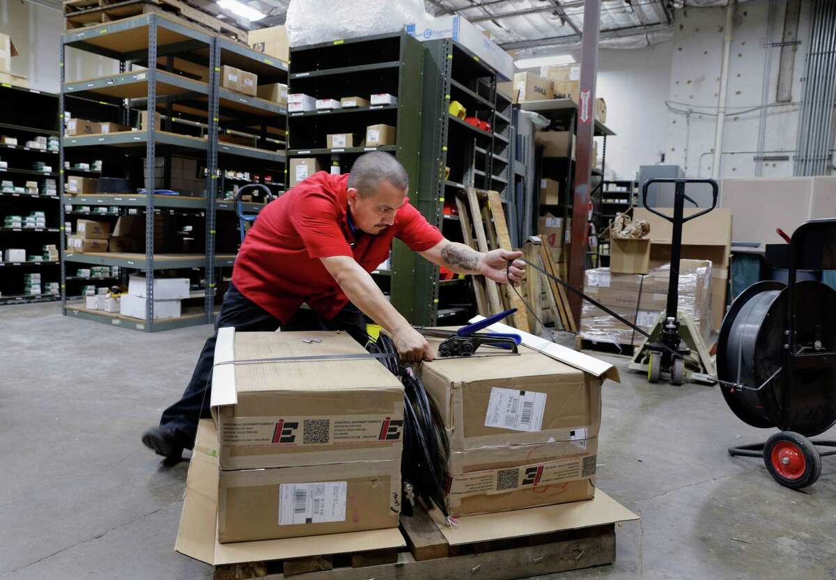 Freddie Garcia puts straps around a pallet of fire scanners he prepares to ship to Texas City in the warehouse of Industrial Equipment Company in Houston, TX, June 21, 2017. (Michael Wyke / For the Chronicle)