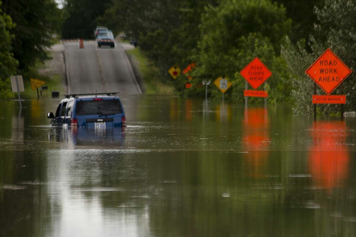 A vehicle is partially submerged in floodwater on N. Sturgeon Road north of Airport Road on Friday, June 23, 2017.