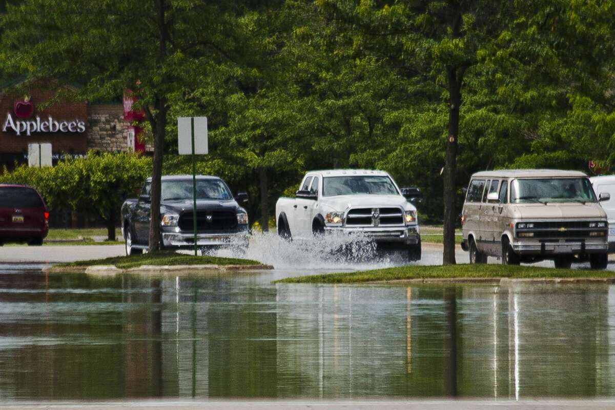 Drivers navigate through floodwater on Mall Drive near the Midland Mall on Friday, June 23, 2017.
