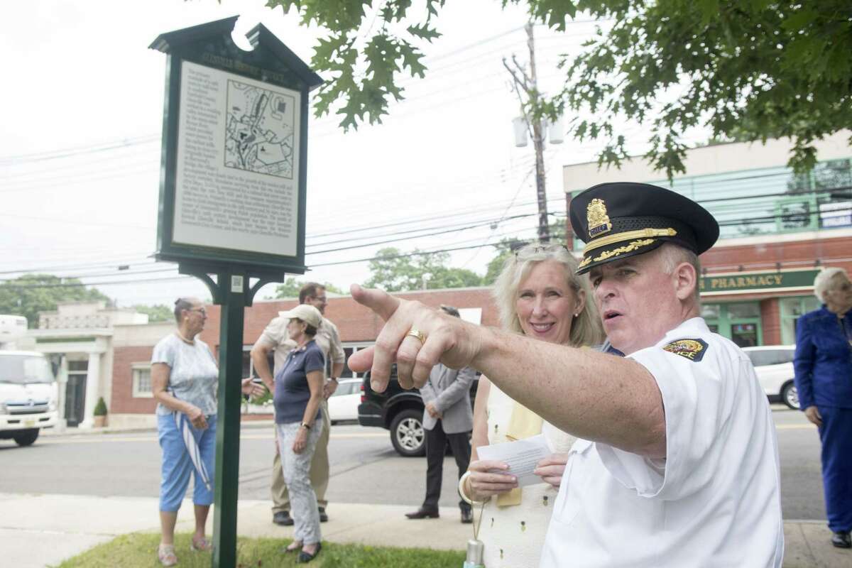 Greenwich Police Chief Jim Heavey discusses some of Glenville's history with Debra Mecky, Executive Director of the Greenwich Historical Society, as the Greenwich Historic Preservation Network hosts a dedication ceremony for the new sign marking Glenville as an historic district in Greenwich, Conn., June 23, 2017.
