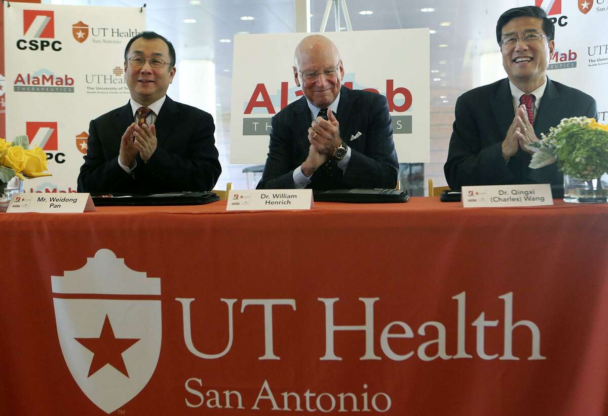 Dr. William Henrich, (center) President of UT Health San Antonio, claps with Mr. Weidong Pan (left) and Dr. Qingxi (Charles) Wang after an official signing celebrating global research and license agreements for two biologic therepeutics for spinal cord injury and breast cancer bone metastasis with UT Health San Antonio and AlaMab Therapeutics, Inc, a subsidiary of CSPC Pharmaceutical Group Ltd. .