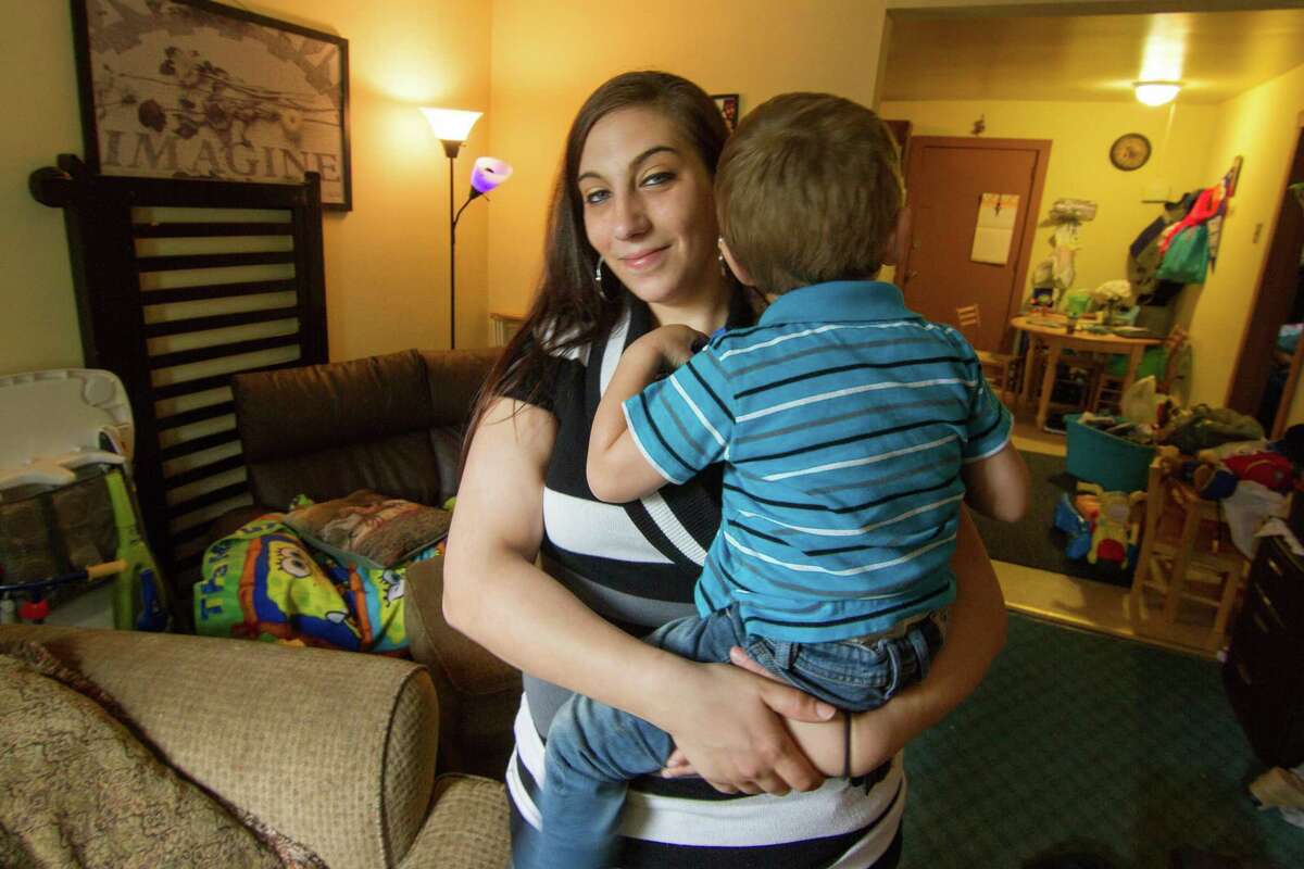 Samantha Collins holds one of her two sons in the living room of her home in Somers. She says she was happy that the DCF Family-Based Recovery Program provided home based support while she was receiving addiction recovery services.