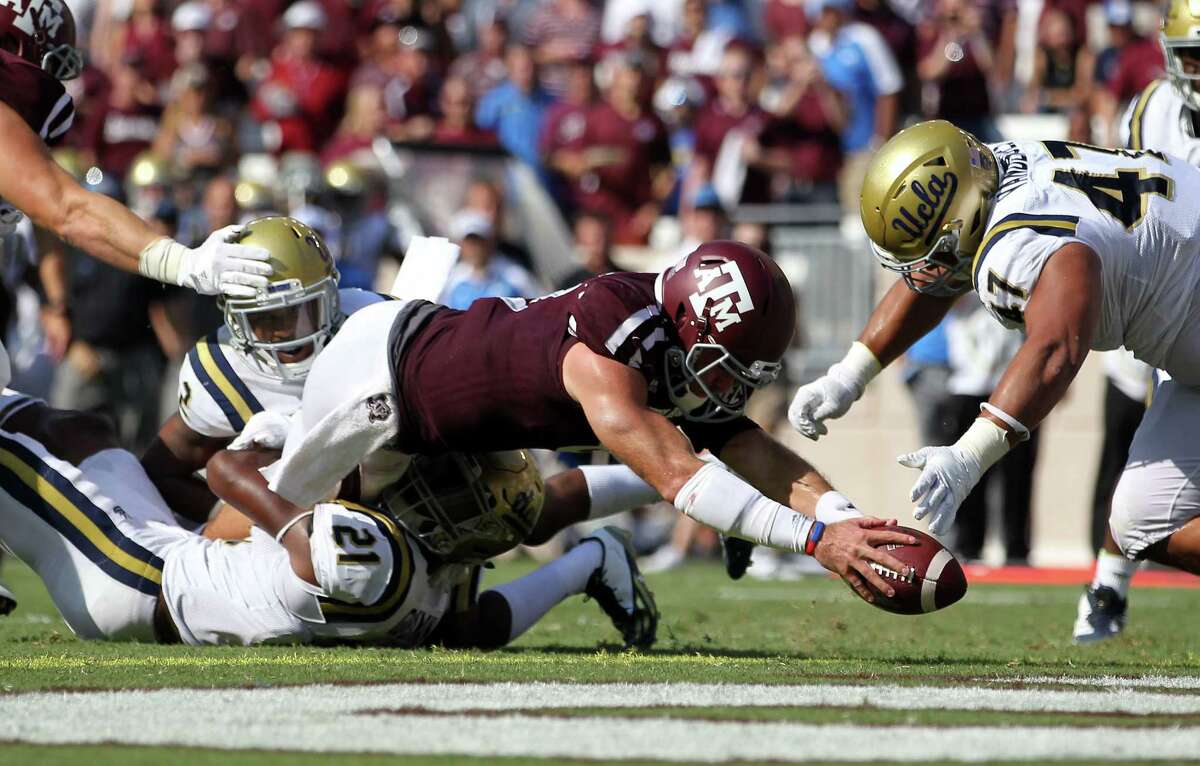 Texas A&M quarterback Trevor Knight (8) dives over the goal line for a touchdown as UCLA defensive back Tahaan Goodman (21) attempts to tackle him during the third quarter of an NCAA college football game Saturday, Sept. 3, 2016, in College Station, Texas. (AP Photo/Sam Craft)