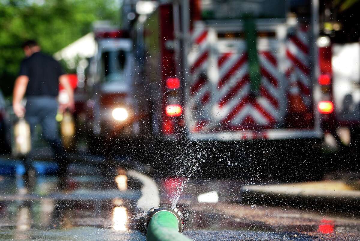 Water sprays from a hose as the Houston Fire Department crews battled a blaze at an apartment complex on Upland near Sherwood Forest in 2013. (Chronicle File Photo)