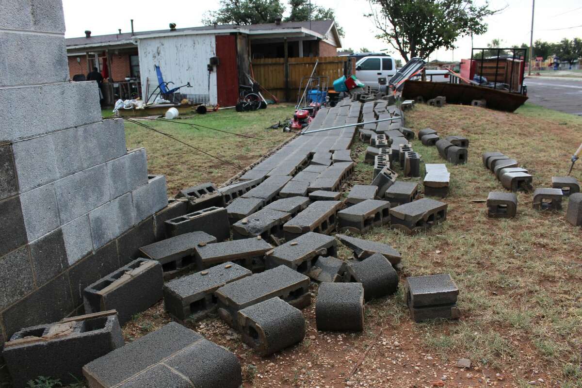 The concrete block fence was completely knocked down from the heavy winds that rolled through Midland Friday evening.