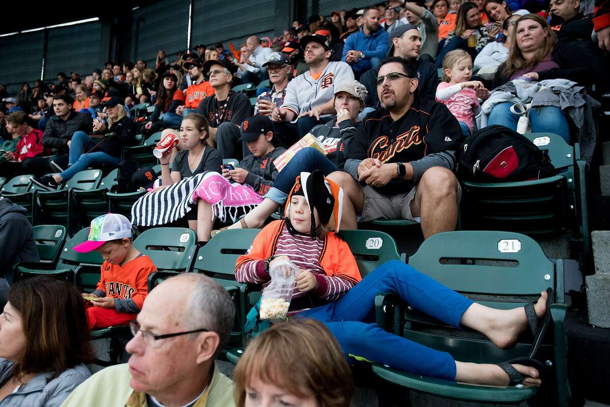 Max Robinson, 10, lounges across seats while watching the Giants lose to the Mets.