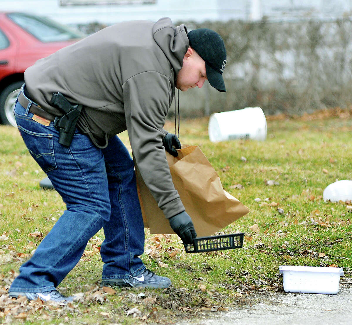 In this Jan. 25, 2017 photo, Elwood, Ind. police bag evidence as they investigate an armed robbery at Low Cost Prescriptions in Elwood, Ind., where one robbery suspect was shot and wounded by police. Law enforcement and pharmacies in Indiana are fighting back against a wave of pharmacy robberies that followed a state crackdown on opioid abuse. Those pill-robbing crimes surged in the state during 2015, when Indiana topped the nation with 168 such heists targeting painkillers and other potent drugs. (John P. Cleary /The Herald-Bulletin via AP)