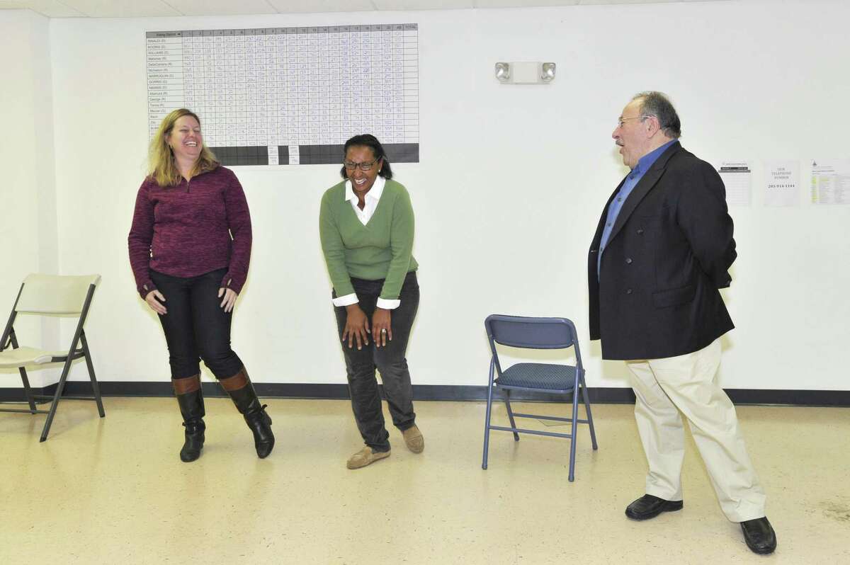 FILE — Monica DiCostanzo, left, and Jennienne Burke share a laugh with John Mallozzi after hearing that Ms. Burke won the open Board of Education seat on Nov. 3, 2015 at the Democratic Headquarters.