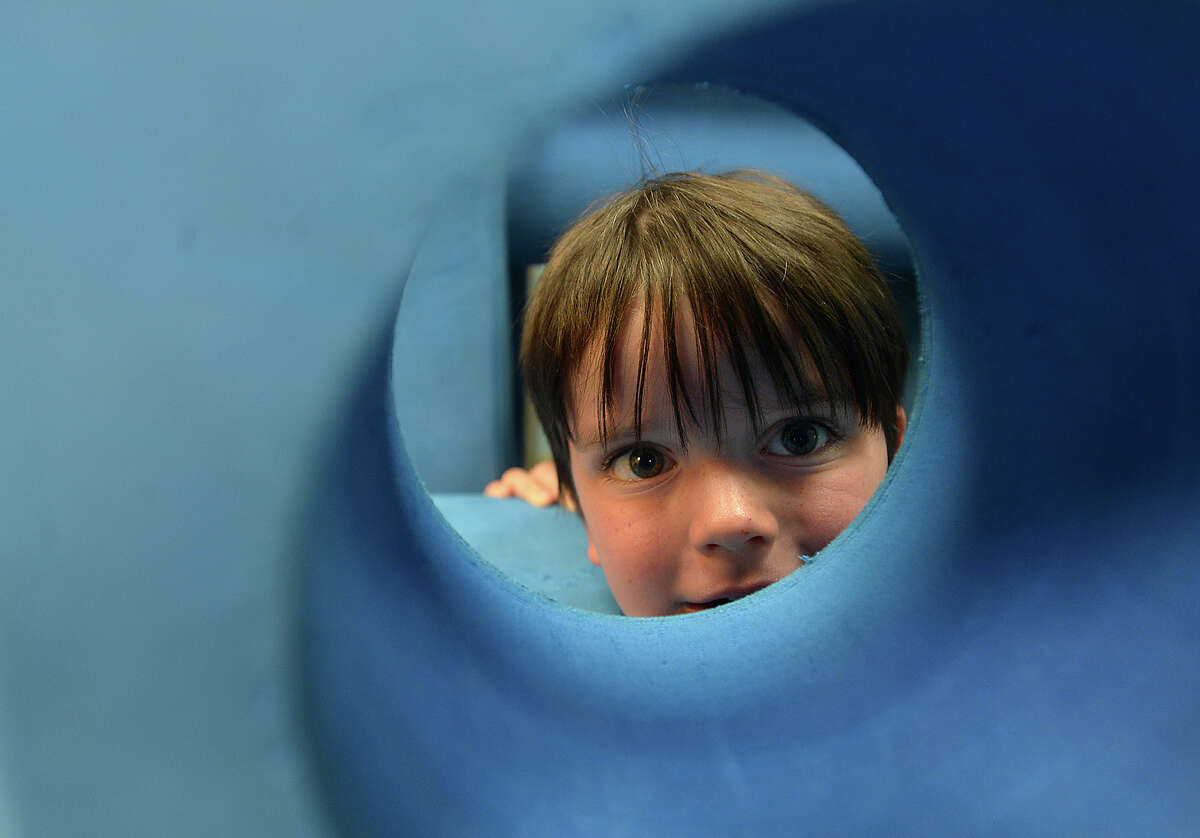 Benjamin David Perkinz, 3, peers out from a hole in a foam building block as he and other children play inside the Imagination Playground at the Beaumont Children's Museum. Perkinz and family were among the many who filled the museum for its Lego Day event and other activities Saturday. Photo taken Saturday, June 24, 2017 Kim Brent/The Enterprise