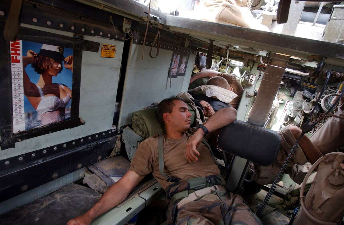Air Force Cpt. Shad Magann, SSg. Travis Crosby, and Spc Bryan Slick sleep in the back of an armored vehicle after an overnight and early morning fight for control of Saddam International Airport Friday, April 4, 2003 in Iraq. BAHRAM MARK SOBHANI/STAFF