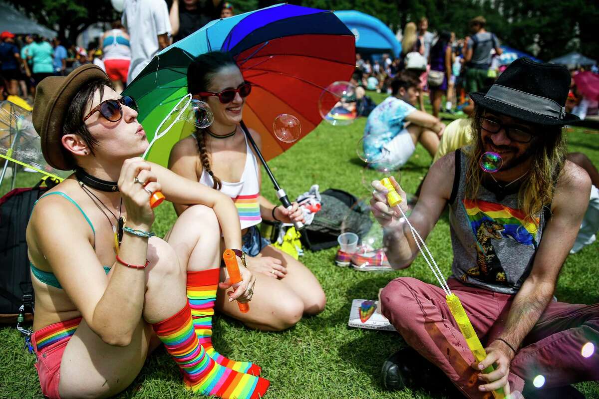 Ruthie Ocean, left, blows bubbles as she sits with Sarah Elaine, center, and Stephen Ferguson during the Houston Pride Festival Saturday, June 24, 2017 in Houston.