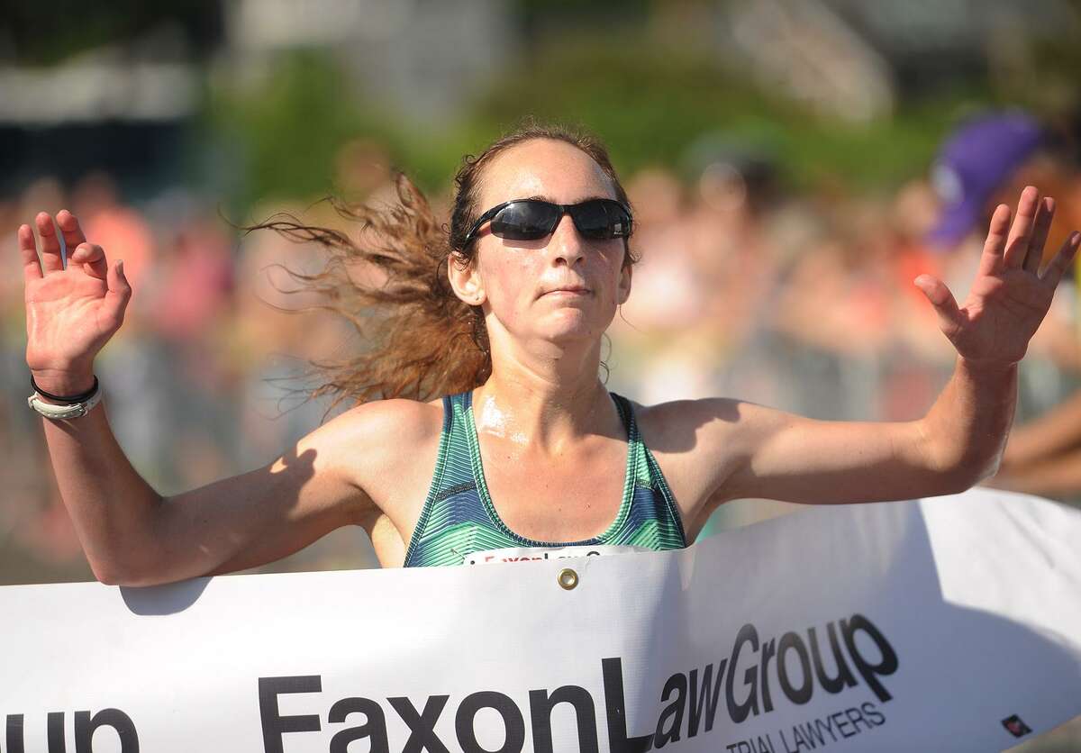 Annmarie Tuxbury of New Hartford breaks the tape as the women's winner of the Fairfield Half Marathon in 1:20:11 at Jennings Beach in Fairfield, Conn. on Sunday, June 25, 2017.