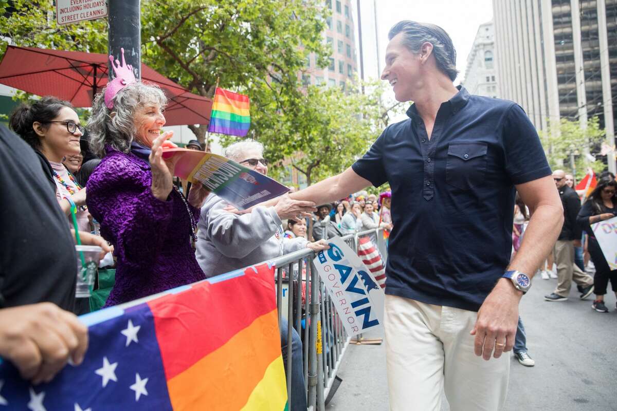 California Lt. Governor Gavin Newsom shakes hands during the San Francisco Pride parade in San Francisco on June 25, 2017