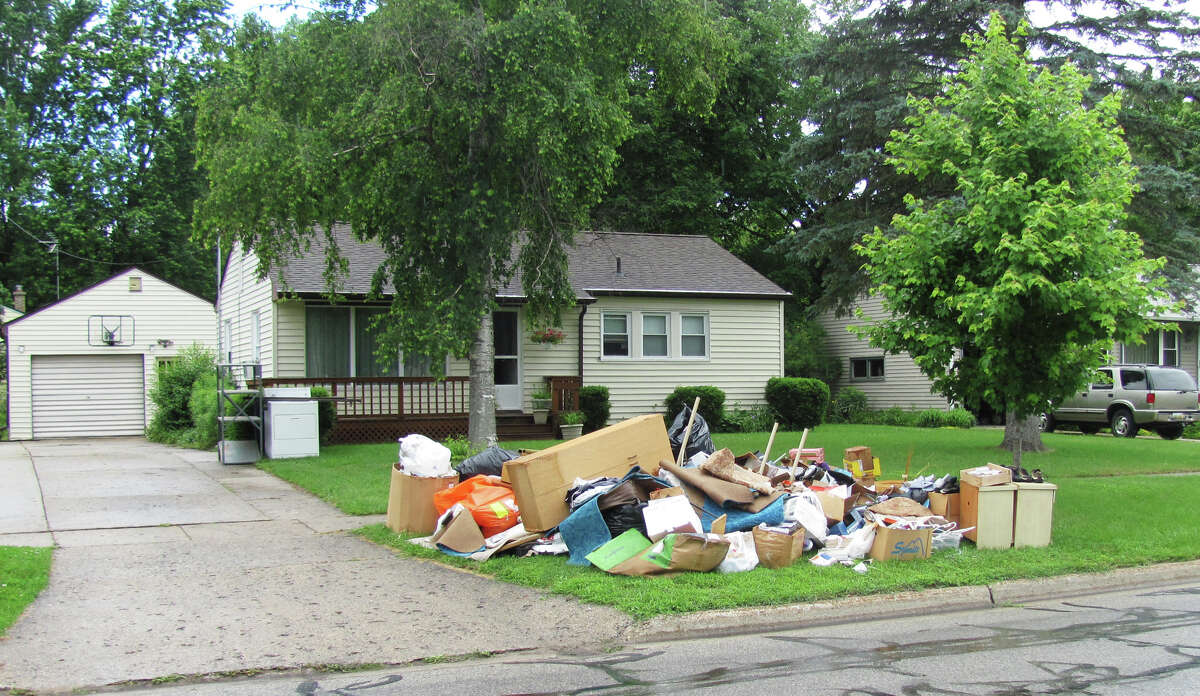 Items that were damaged when Lisa Sanders' basement flooded are piled in front of her home on Sunday, June 25, 2017.