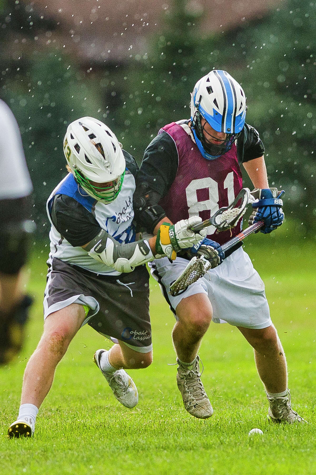 Momentum Lacrosse Black's Ryan Slank of Rochester Hills, right, fights for possession with a Cobalt Classics opponent, left, during the Great Lax Bay Classic on Saturday in Saginaw.