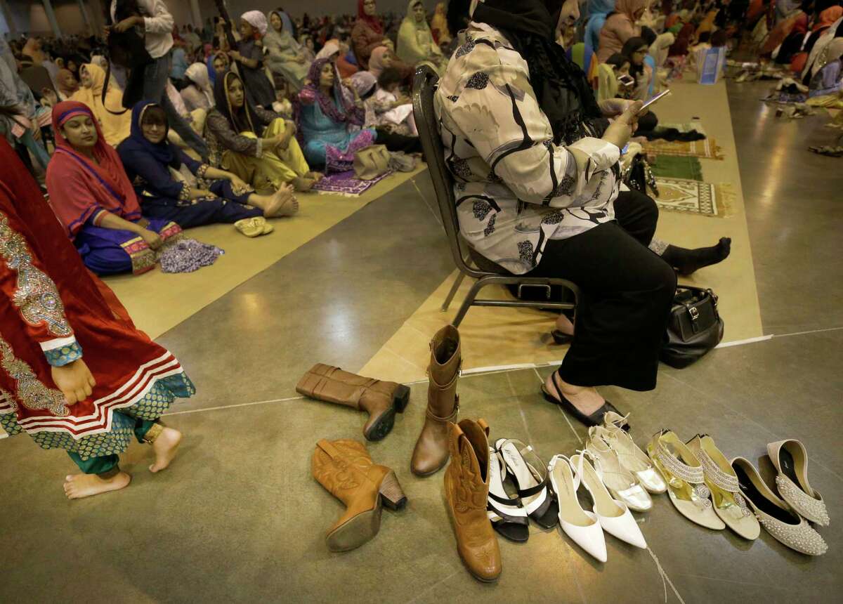 Various shoes are placed at the end of an aisle during the prayer ceremony. The service takes up two halls in NRG Center: one for men, the other for women.