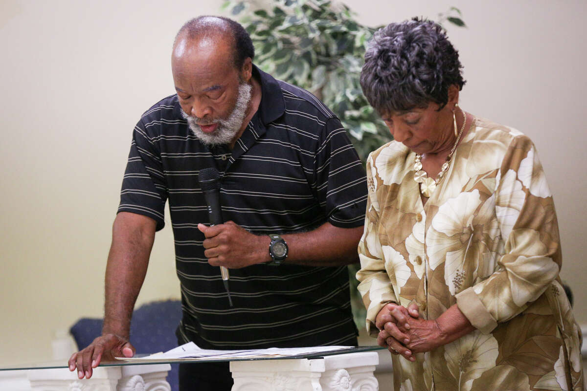 Mistress of Ceremony Hallie James Williams, right, bows her head as Henry Calyen gives the invocation during the Booker T. Washington Alumni Association 12th Annual Scholarship Banquet on Saturday, June 24, 2017, at Union Center AME Church in Conroe.