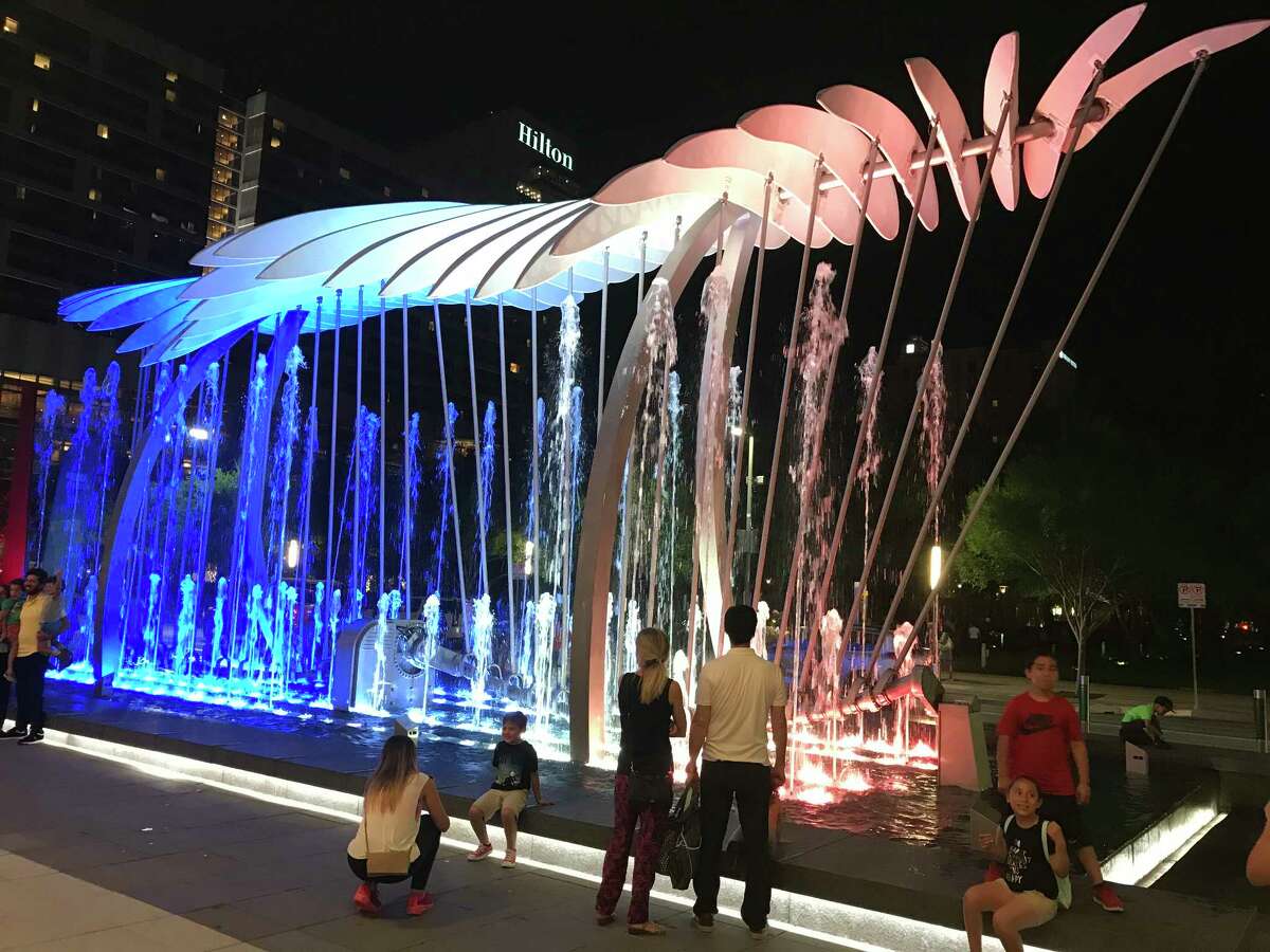 Visitors enjoy the "Wings over Water" sculpture that's installed within a fountain front of the George R. Brown Convention Center.