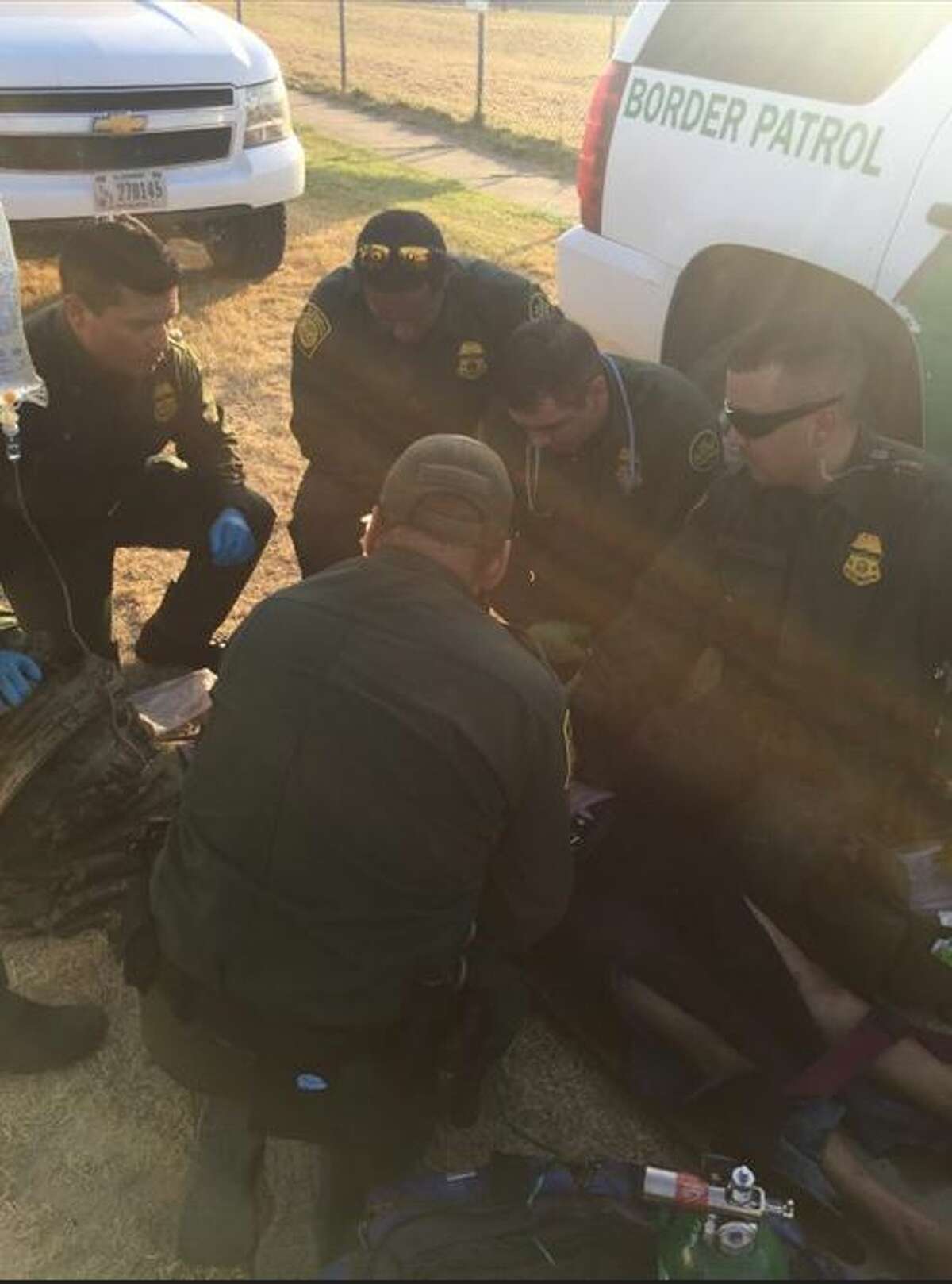 Border Patrol agents attend to a female immigrant who showed signs of suffering from a heat stoke. 