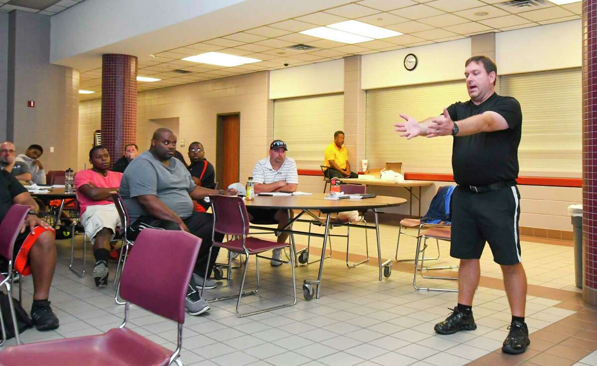 TASO crew chief and trainer Eric Dumatrait utilizes in-room props to simulate a football field environment, as his class of referee-trainees looks on. Dumatrait has to get through the entirety of the NCAA rulebook, 203 very dense pages of information, along with idiosyncratic UIL/high school rule variations, mechanics and etiquette in four class sessions in order to prep them for real-world officiating situations.