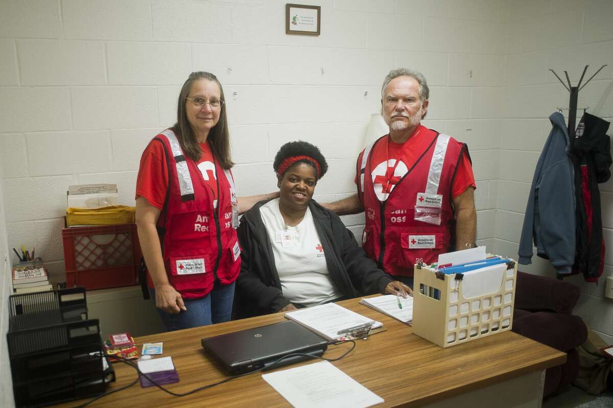 From left to right, Red Cross volunteers Cynthia Woiderski of Midland, Sharron Hall of Flint and Larry Woiderski of Midland pose for a portrait inside a Red Cross shelter at the West Midland Family Center at 4011 W. Isabella Road on Monday, June 26, 2017.