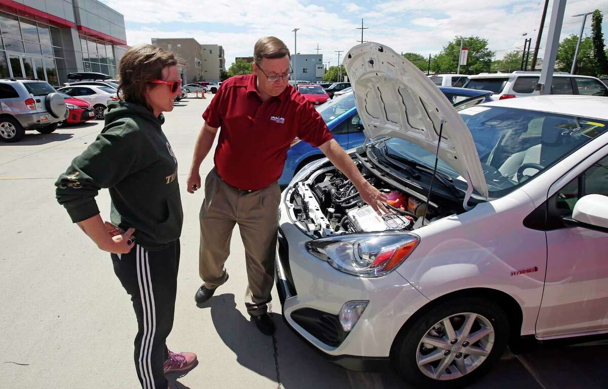 Salesman Doug Lund shows the engine of a Prius C hybrid to Mary Jean Jones in Salt Lake City. Auto sales have declined for five straight months.
