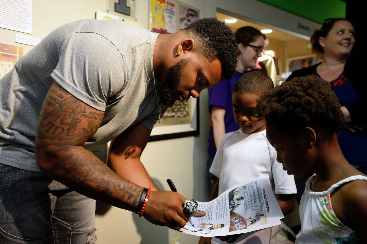 New England Patriots linebacker Elandon Roberts signs an autograph for Jeremy Johnson, 8, and Eriyohn Mickens, 6, during an induction ceremony into the Museum of the Gulf Coast's sports hall of fame on Monday. Photo taken Monday 6/26/17 Ryan Pelham/The Enterprise