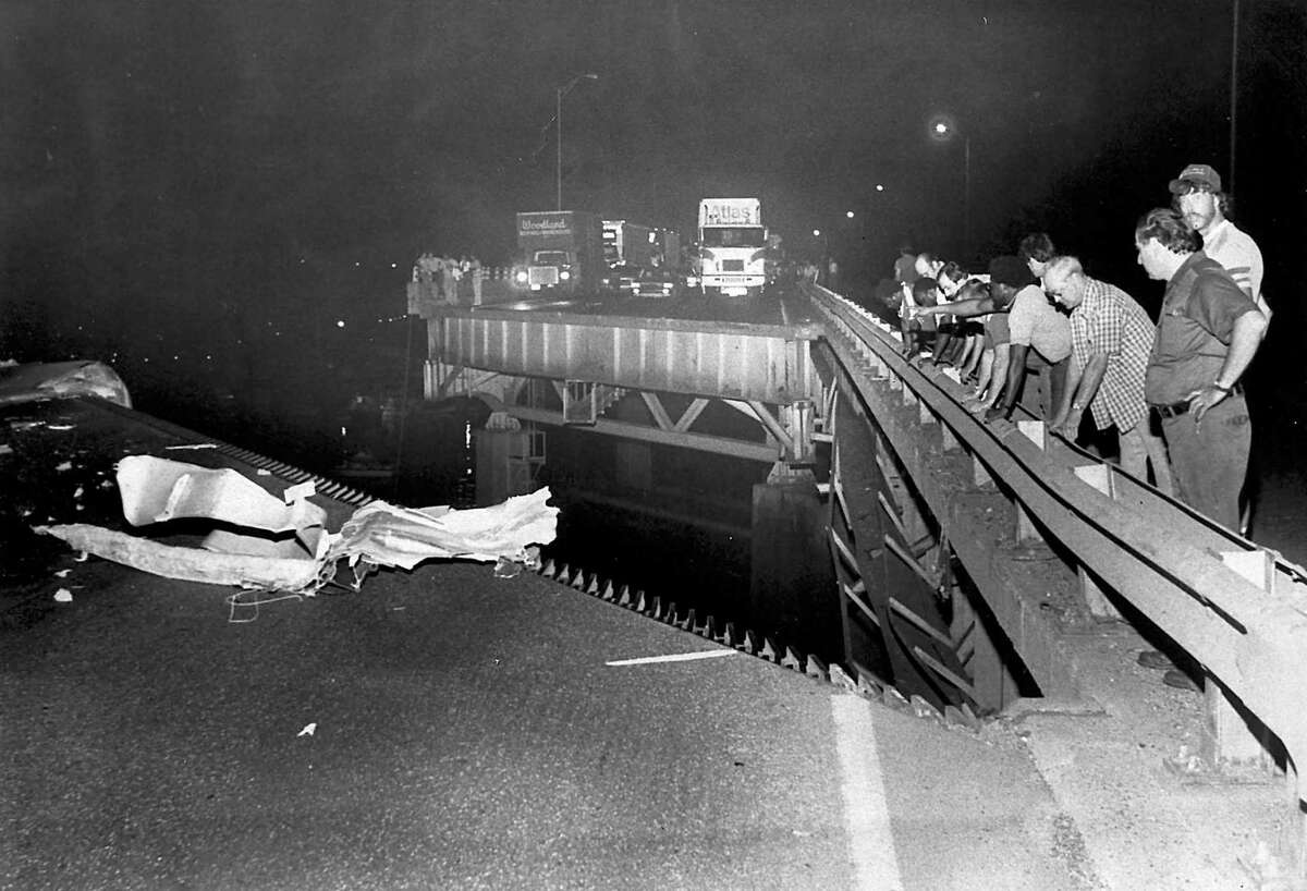 Spectators look at the damage the night of the Mianus River Bridge collapse June 27, 1983.