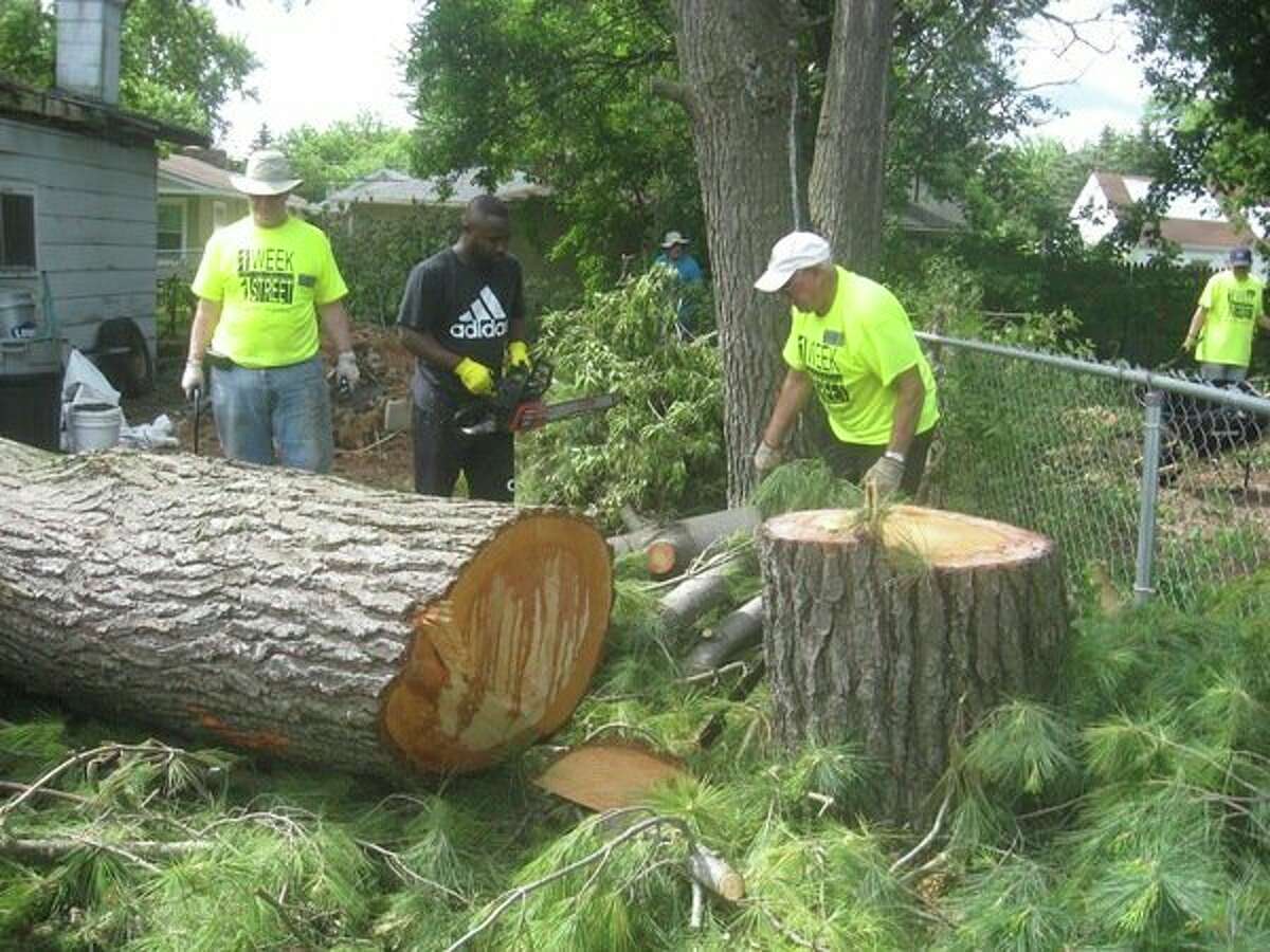 Mike Fisher, Calvin, Chuck Zemanek and Greg Janoch work to clean up trees on a property in Saginaw during the fifth annual One Week One Street event. (Photo provided)