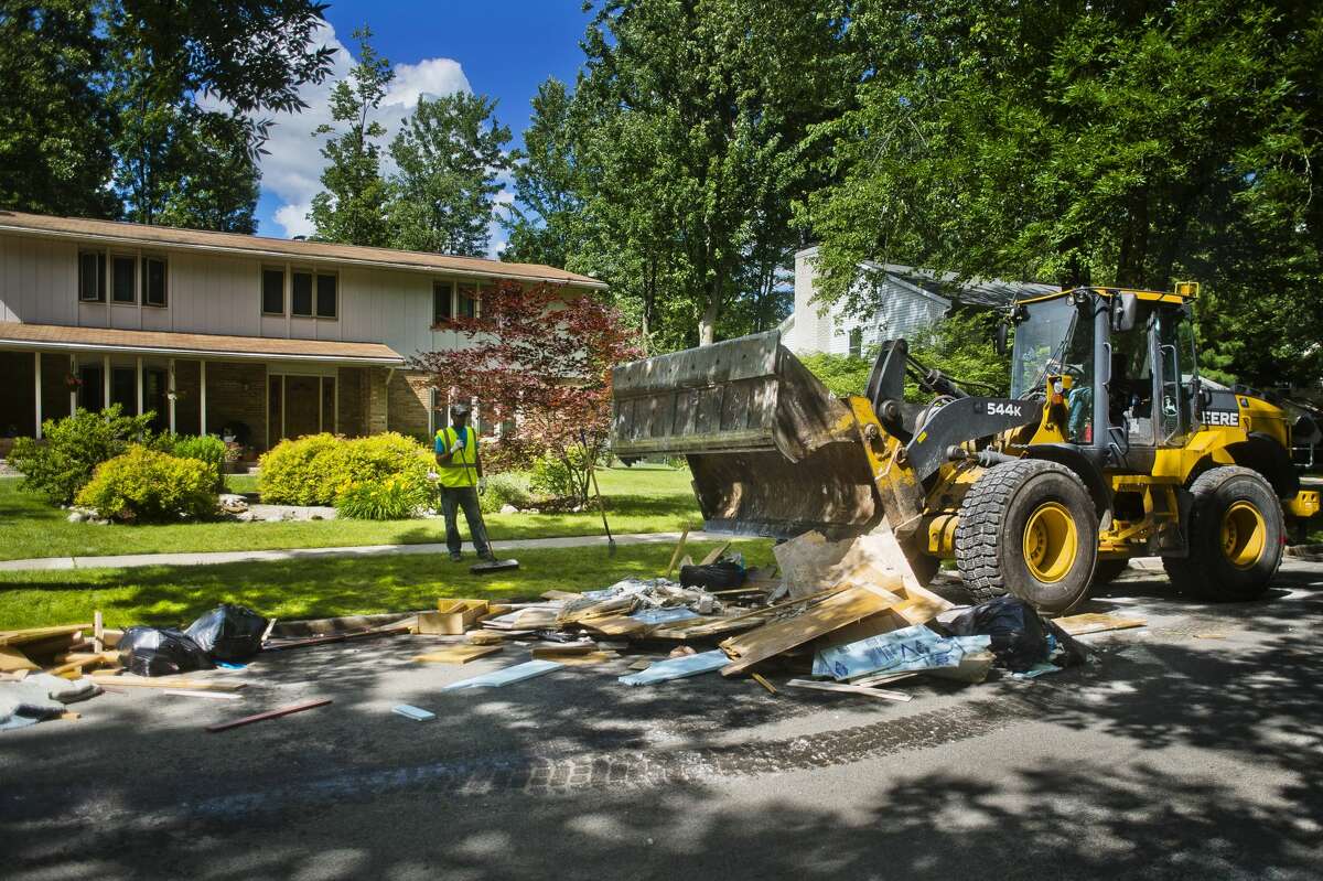 City crews work to remove damaged belongings from houses affected by flooding near the corner of Nakoma Drive and Morning Way on Monday, June 26, 2017.