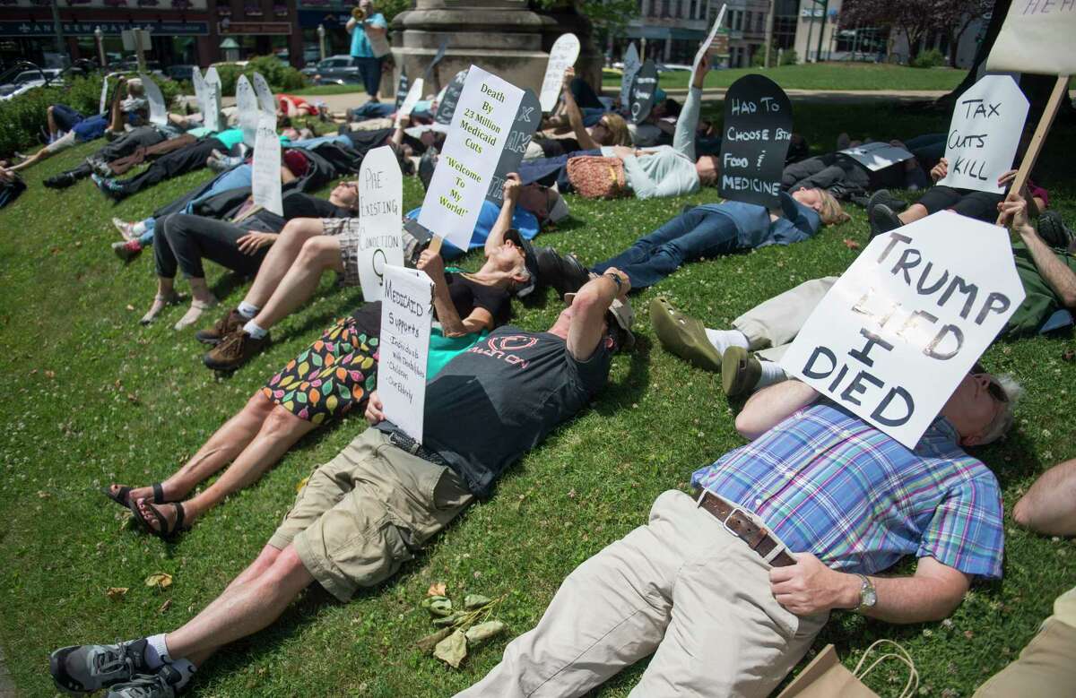 Local concerned citizens gather to protest the current health care bill being considered in the Senate with a "Die-in" at the Monroe County Courthouse in Bloomington, Ind. Monday, June 26, 2017. (Chris Howell/The Herald-Times via AP)
