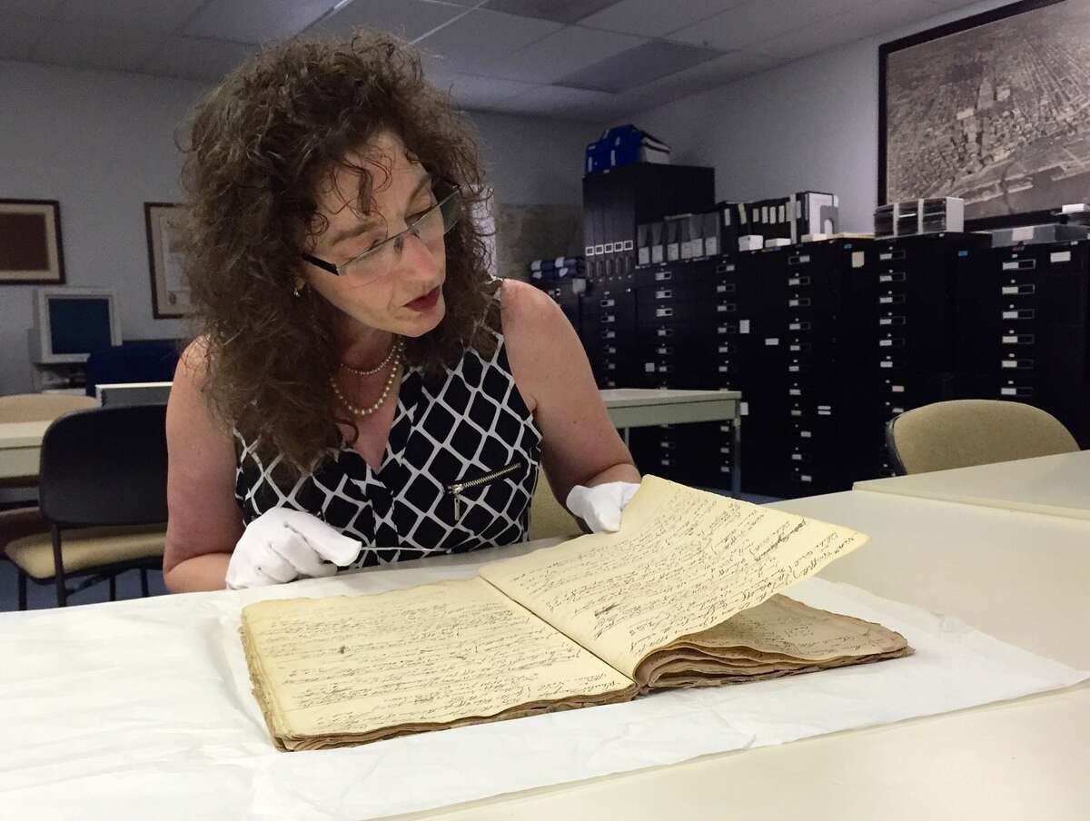 Historian Tricia Barbagallo looks through the Colonial-era Adgate ledger at the Albany County Hall of Records, which she helped rescue after she tipped off investigators when she saw it for sale illegally on eBay. (Paul Grondahl / Times Union)