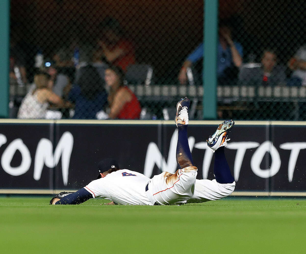 Astros right fielder George Springer goes sprawling after making a diving catch of a third-inning fly ball hit by the A's Jaycob Brugman on Tuesday night at Minute Maid Park.