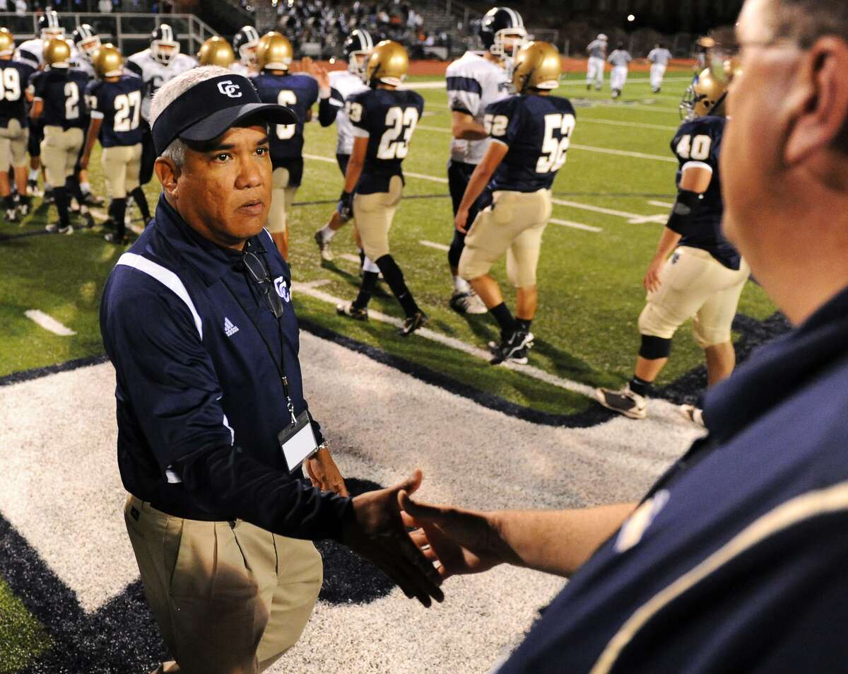 Central Catholic head coach Carlos Enrico shakes hands with Holy Cross coach Arnold Martinez after the Holy Bowl at South San Stadium in San Antonio on Nov. 7, 2009.