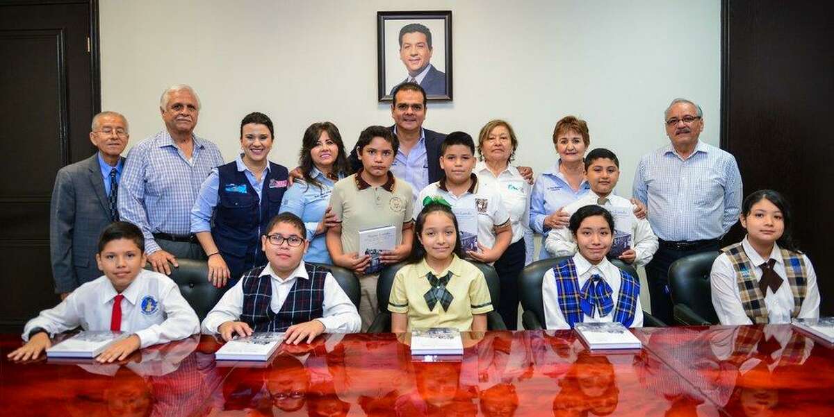 El Alcalde Enrique Rivas posa junto a los estudiantes que representaron a Nuevo Laredo en sala de juntas de la Presidencia Municipal.