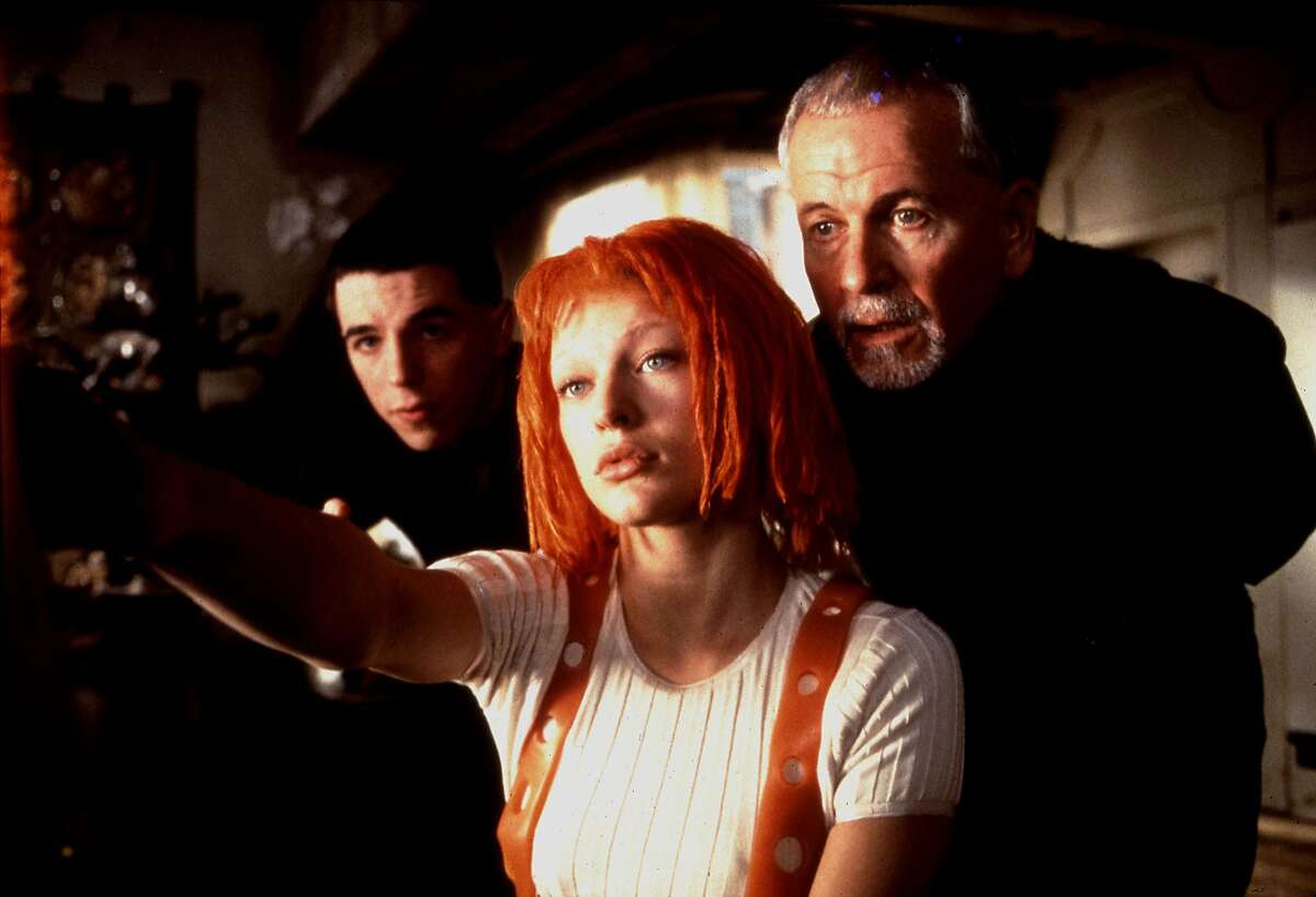 THE FIFTH ELEMENT (1997) -- (l-r) Lee Evans, Mila Jovovich and Ian Holm starred in the 1997 film The Fifth Element from Columbia/Tristar. photo credit: Jack English. HOUCHRON CAPTION (06/29/2005) SECSTAR COLOR: THE RED DREAD: Only this muppetheaded waif can save the world from Evil in Luc Besson's hyperkinetic fantasia. Hey, it beats spinning plates.
