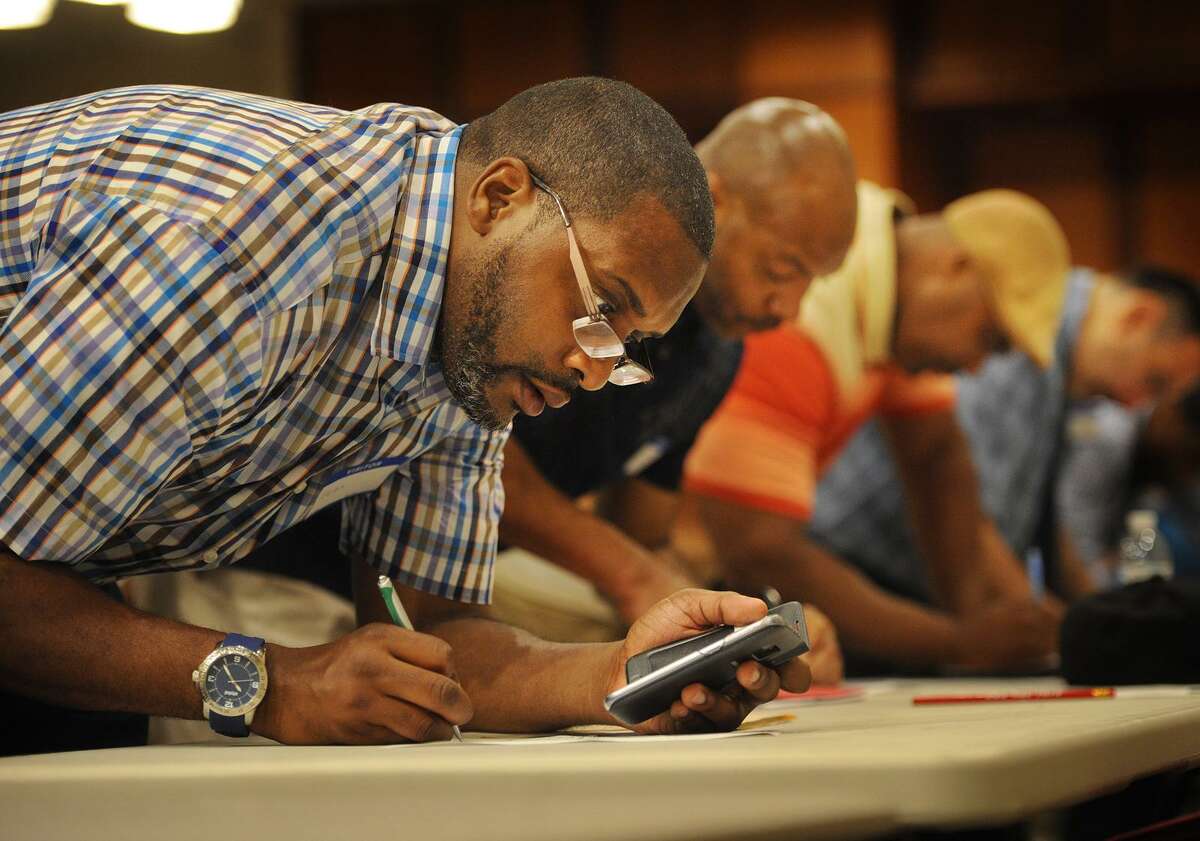 Sean Toliver, left, of Bridgeport, fills out a job application at a job fair for ex-offenders, the Bridgeport Re-Entry Career Fair, at the Margaret Morton Government Center in Bridgeport, Conn. on Wednesday, June 28, 2017.