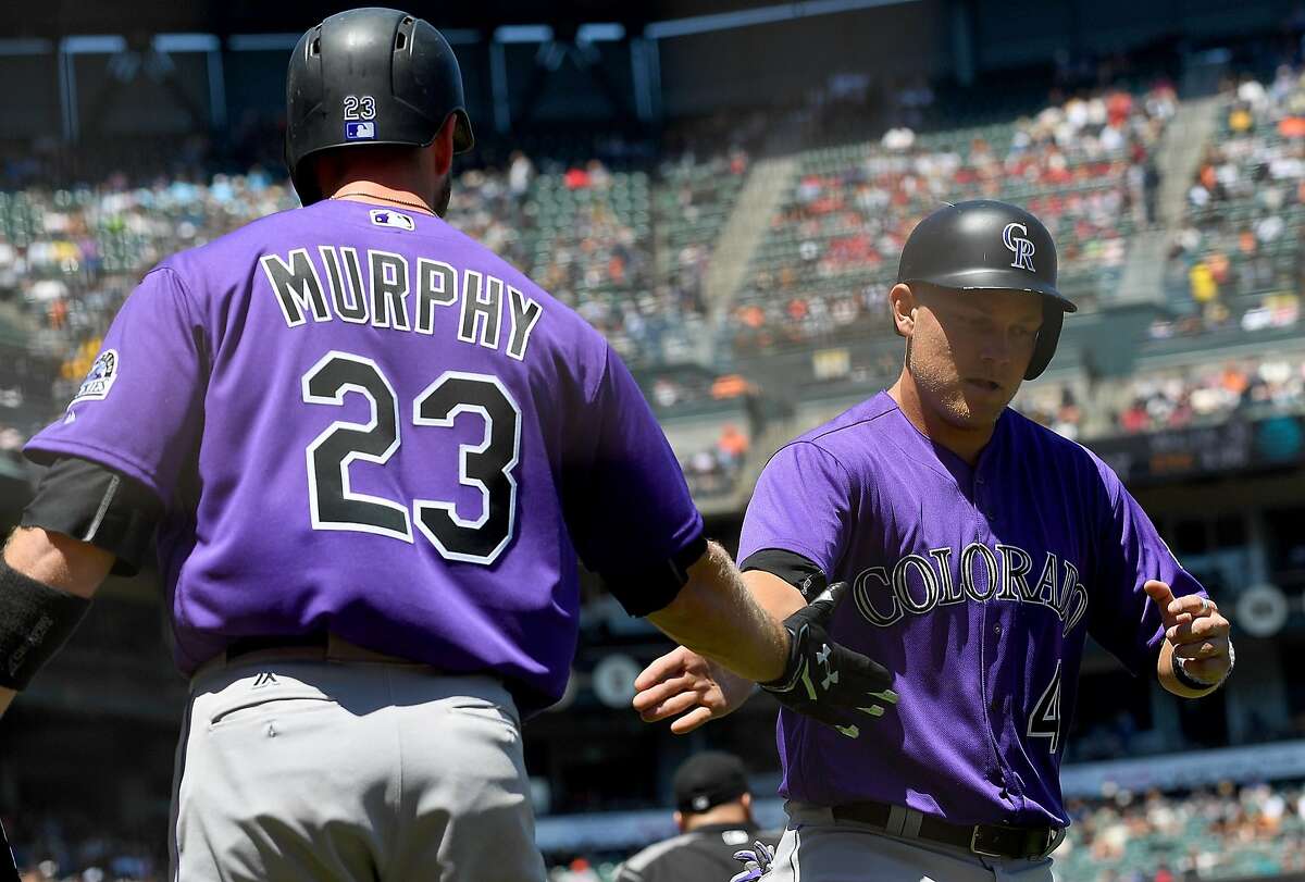 Pat Valaika #4 of the Colorado Rockies is congratulated by Tom Murphy #23 after Valaika scored against the San Francisco Giants in the top of the six inning at AT&T Park on June 28, 2017 in San Francisco, California.