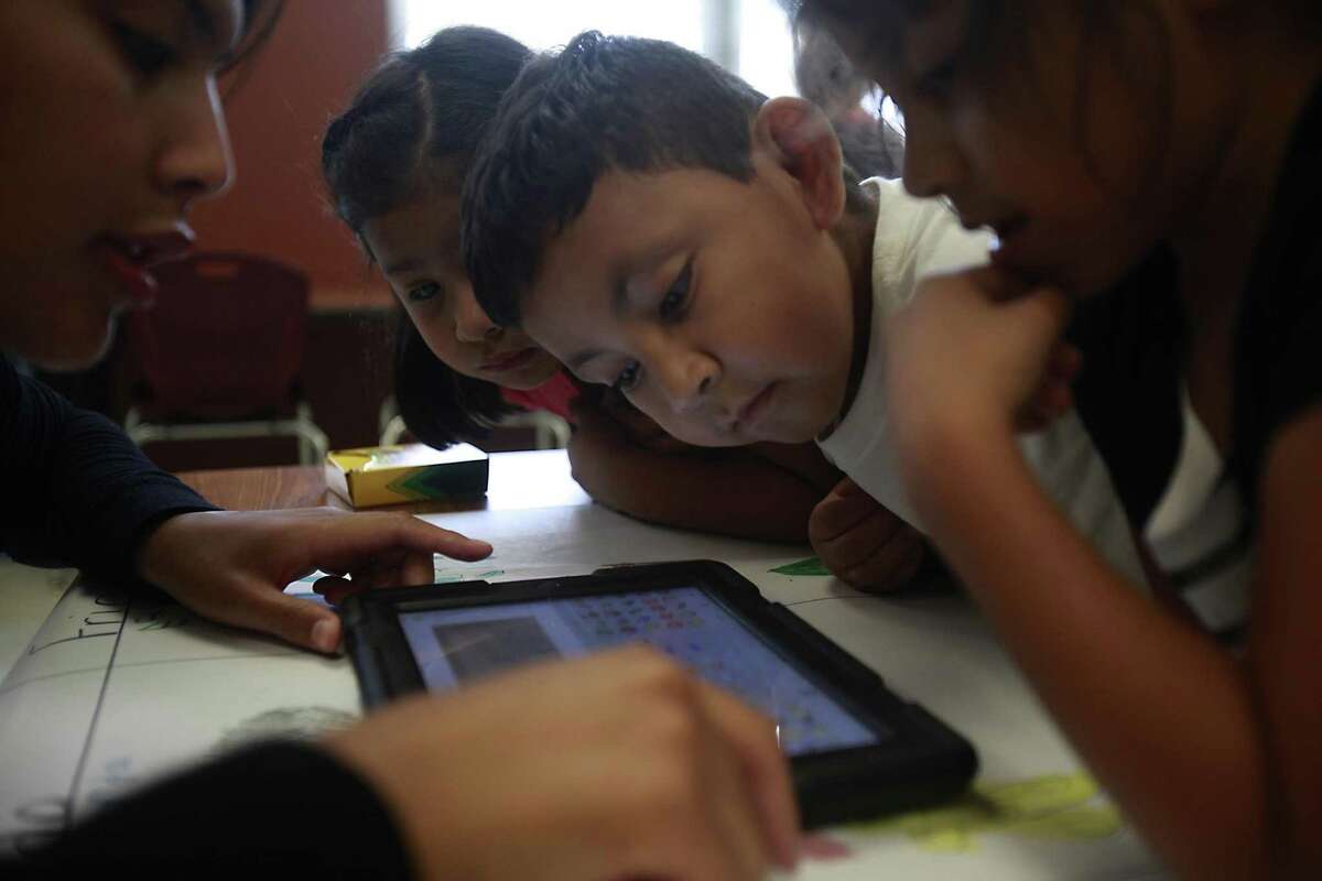 Daniel Escobar, learns how to use emojis to caption his colored picture and tell stories at Losoya Intermediate bilingual summer school.
