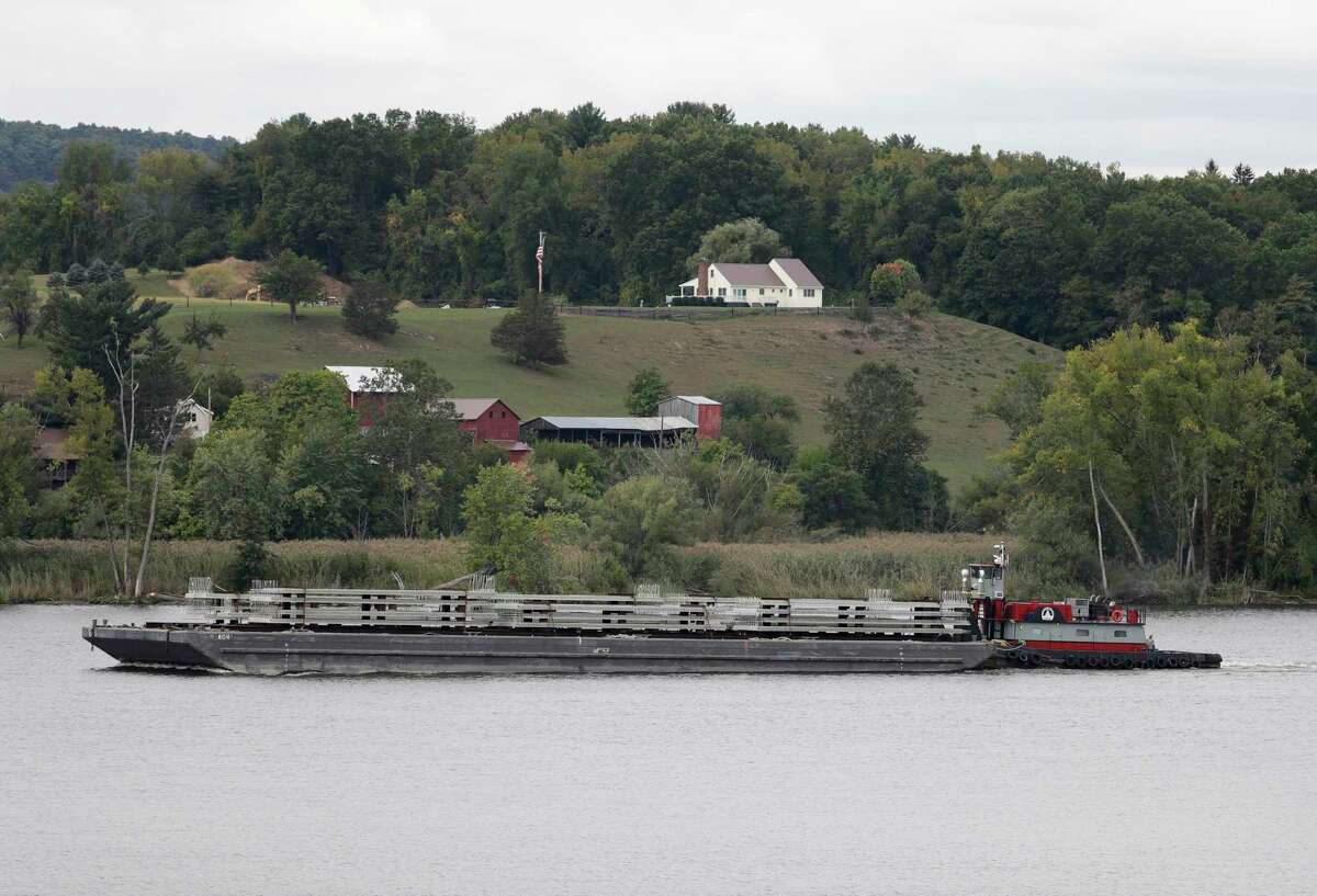 In this Wednesday, Sept. 28, 2016 photo, a tugboat and barge travel south on the Hudson River in Stuyvesant, N.Y. A group of citizens, lawmakers and environmentalists is fighting a proposal to establish more than 40 commercial anchorages at locations along a stretch of the Hudson River running north from New York City. Shipping industry officials said they need safe places to anchor, sometimes for days, barges hauling North Dakota crude oil to East Coast refineries and export terminals. (AP Photo/Mike Groll)   