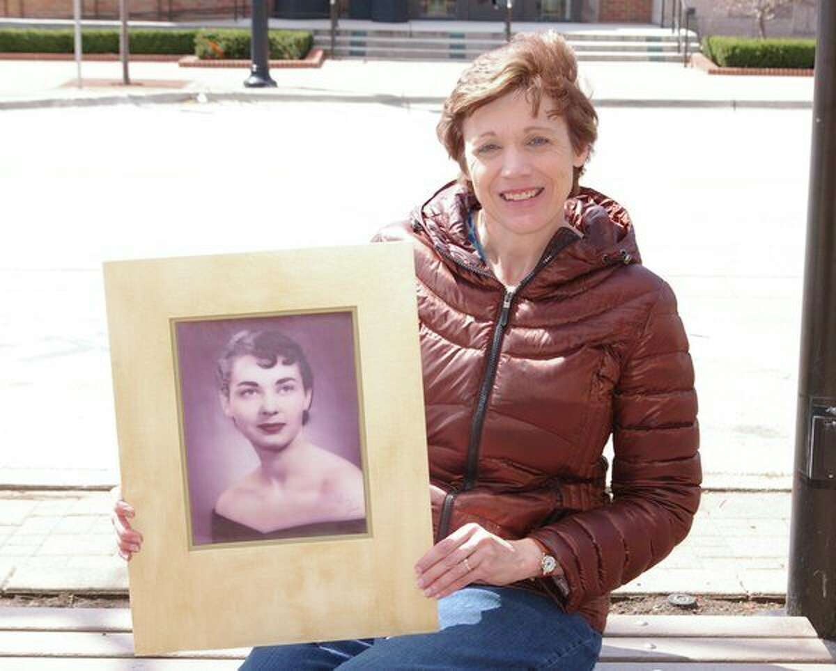 Cindy Lowery holds an earlier photo of her mother, Joan Haskins. Lowery and her family visited Haskins regularly as her health declined. (Niky House/for the Daily News)  