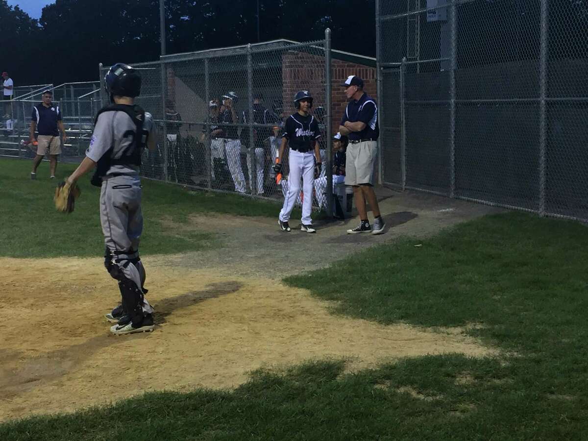 Westport coach Tom Whelan shares some wisdom with one of his players before an at-bat against Fairfield National on Wednesday evening at Unity Field in Trumbull.