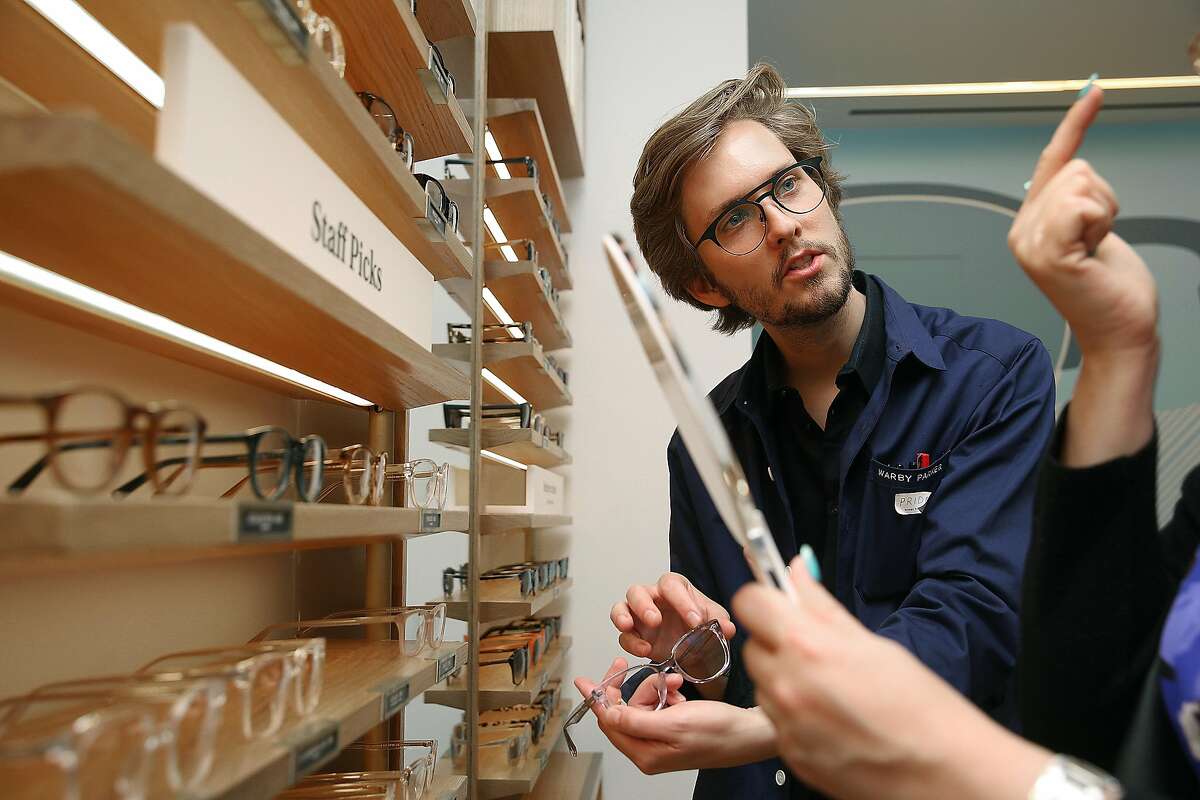 Manager Adam Bentley helps a customer choose glasses at Warby Parker store on Tuesday, June 27, 2017, in west Berkeley�s Fourth Street retail district in Berkeley, Calif.